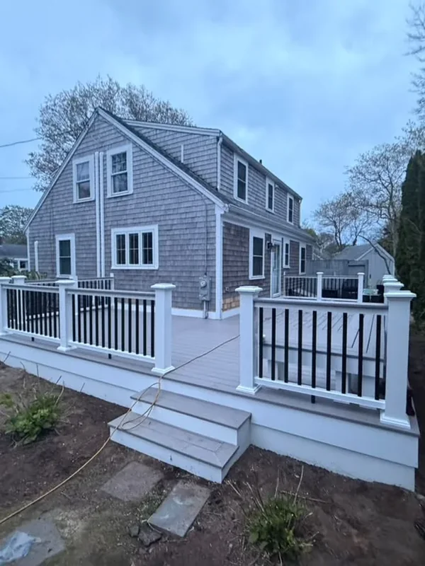 Backyard view of deck with white railing and stairs