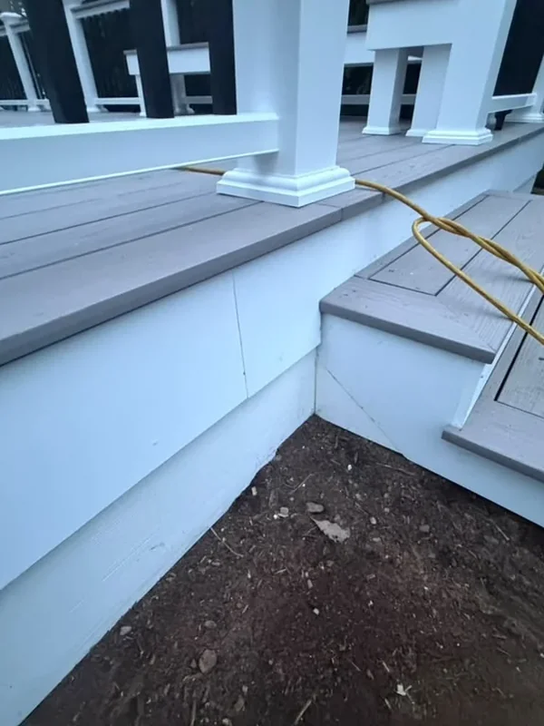 Deck seating area with greenery and white railing
