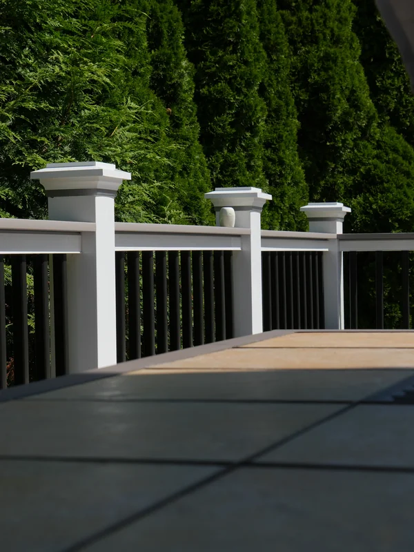 White and black deck railing in a sunny backyard