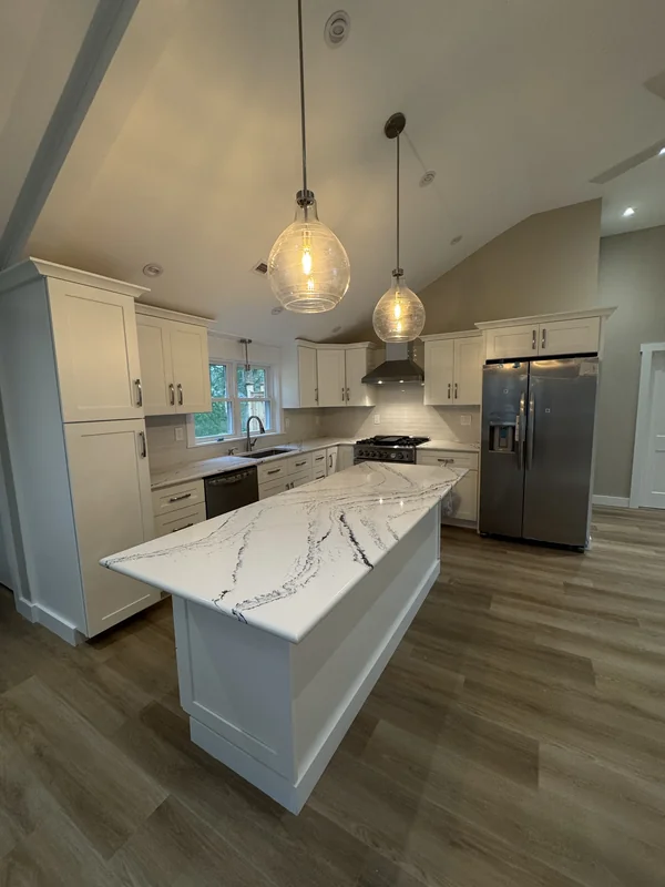 Kitchen island with pendant lights and adjoining living area