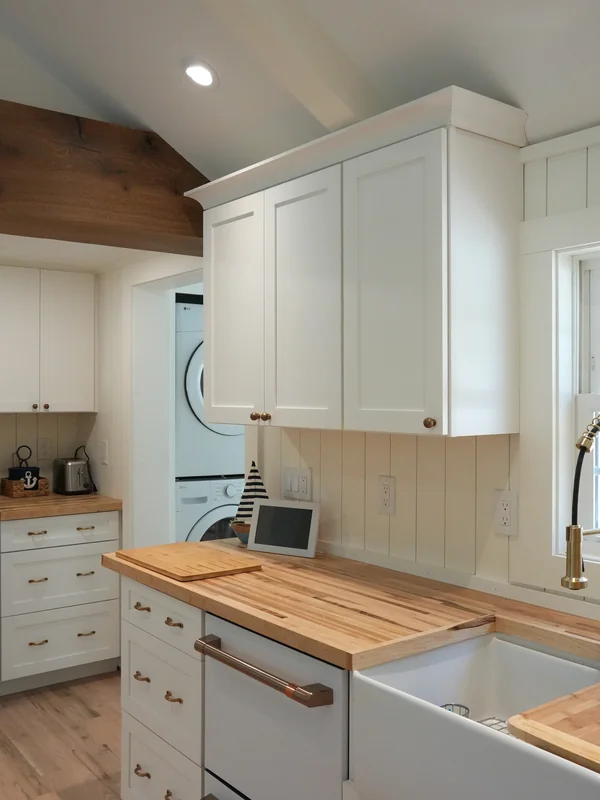 White cabinetry and wood countertop in a finished kitchen