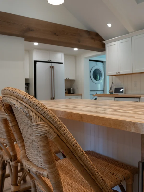 Kitchen island view with wood counter and appliance wall