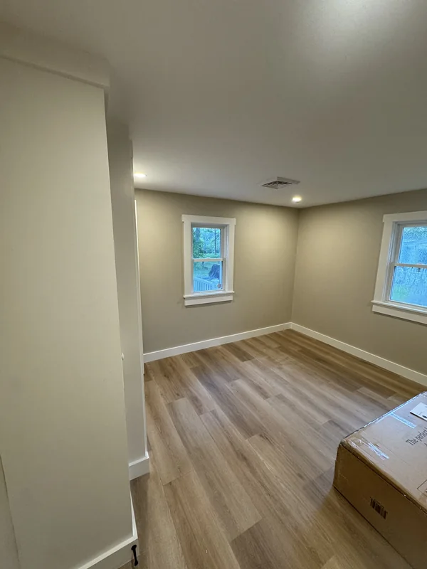 Newly finished room with light wood flooring and neutral walls