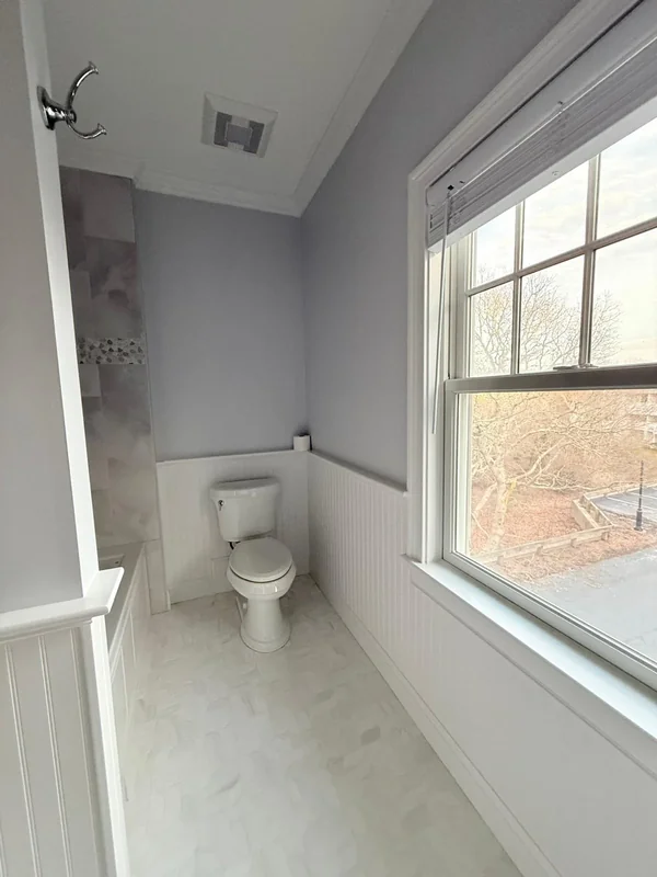 Small bathroom with freshly painted walls and bright window