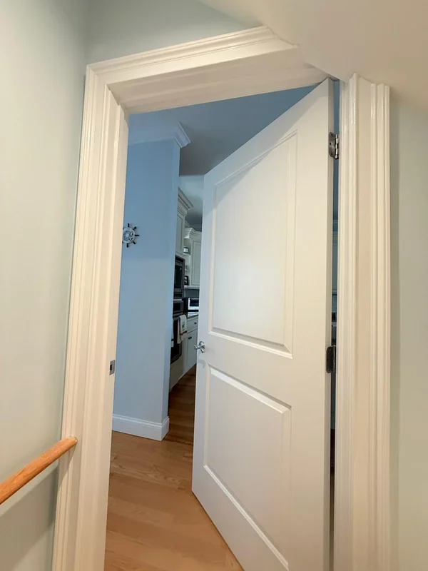 Freshly painted doorway and hallway trim in a home interior