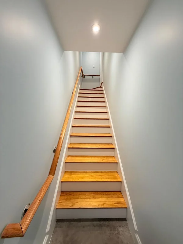 Stairwell with fresh light wall paint and wood stairs