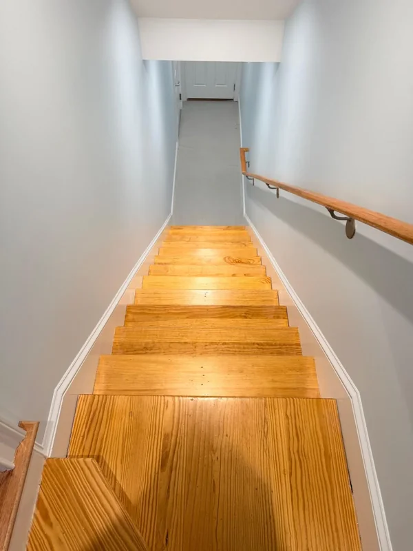 Painted stair landing with warm wood floor and white trim
