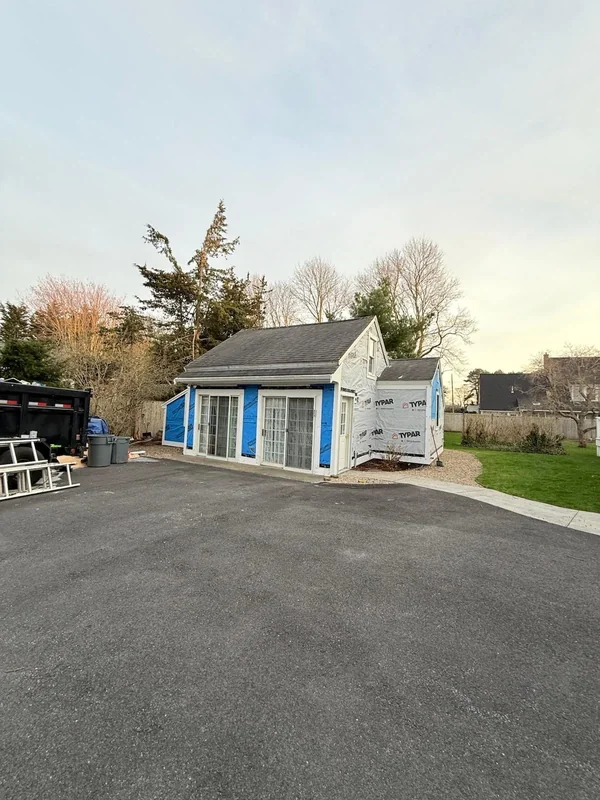Wide driveway view of a finished small exterior building