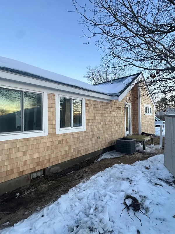 Side exterior wall with cedar shingles and white window trim