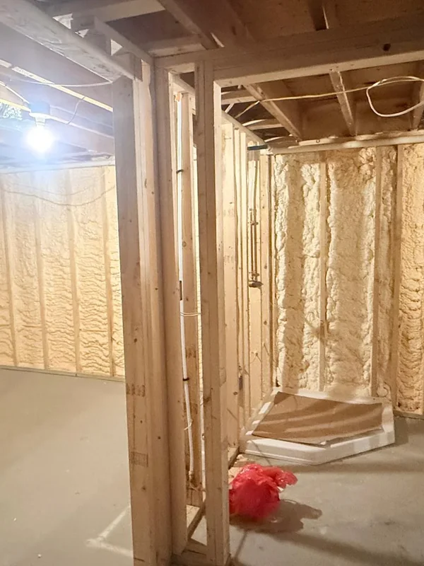 Framed room with spray foam insulation applied to wall cavities