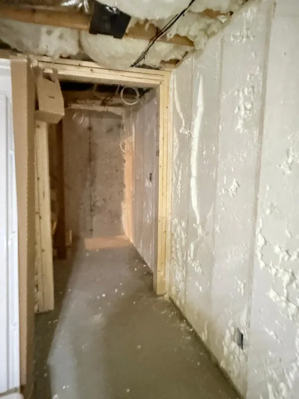 Narrow basement passage with spray foam insulation on both sides