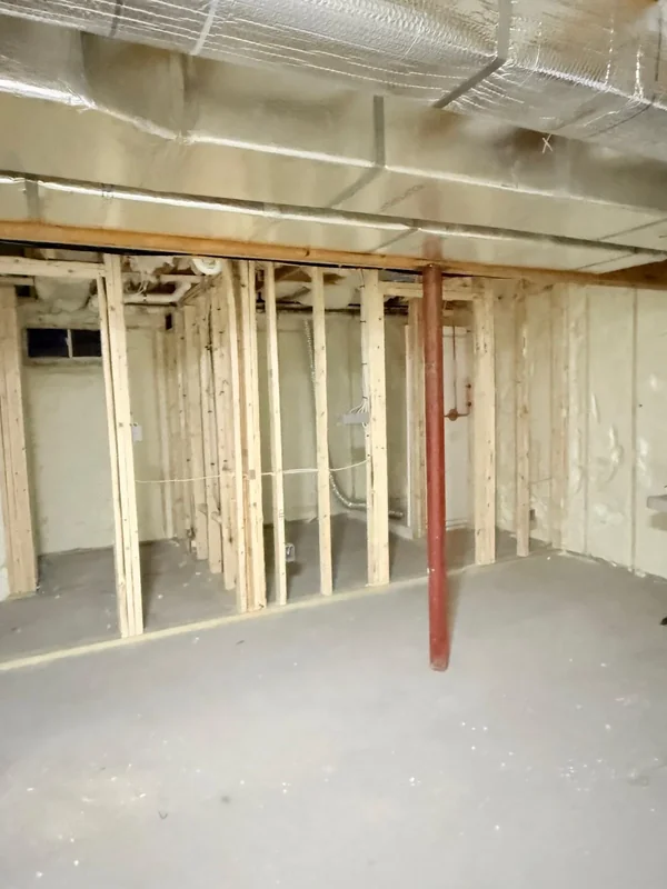 Open basement area with spray foam insulation and framing