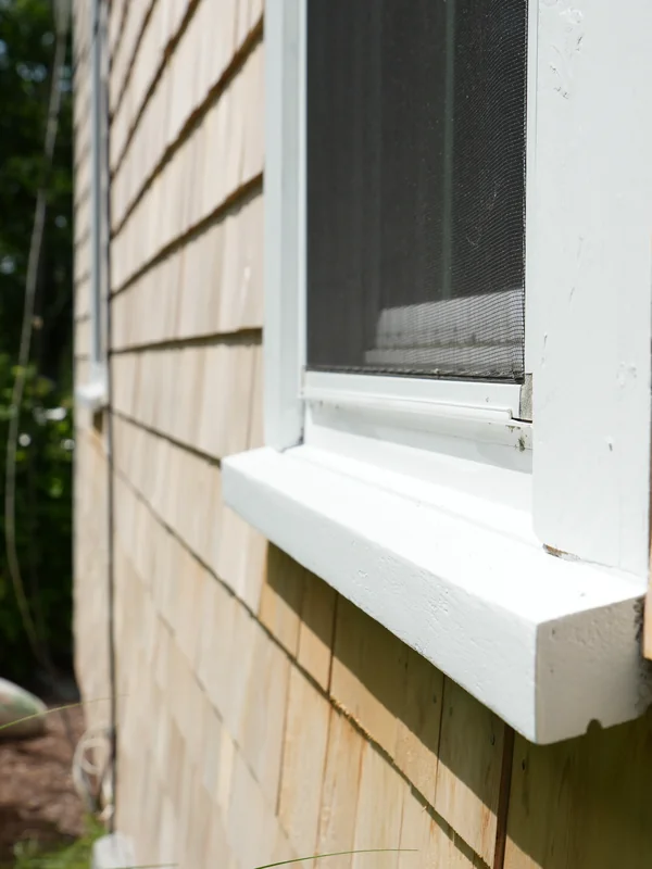 Window sill and trim detail on cedar shingle siding